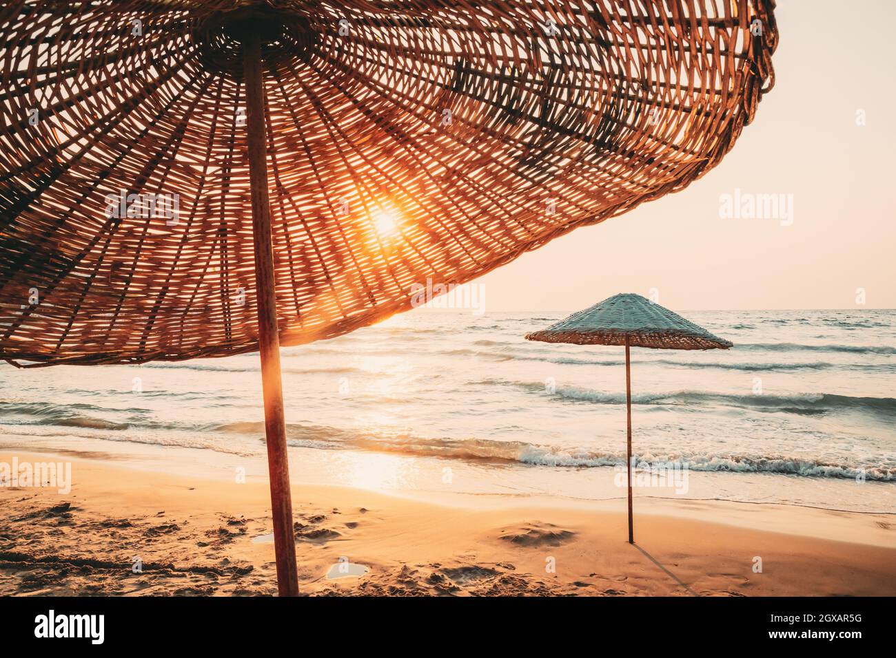 Las sombrillas de playa. Sun Sol a través de la sombrilla de mimbre en  verano Sunrise Sunset Fotografía de stock - Alamy