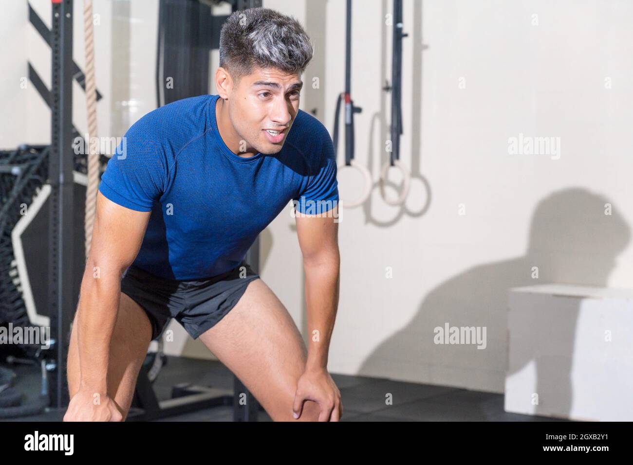 Forma a un hombre joven sudando después de una sesión de ejercicio en el gimnasio. Fotografías de alta calidad. Foto de stock