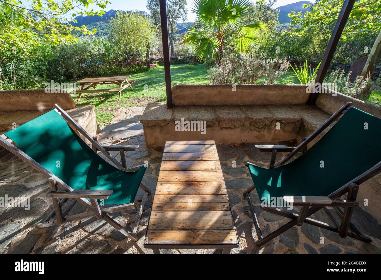 Casa de campo con porche con tumbonas de lona plegables. Concepto de turismo rural. Foto de stock