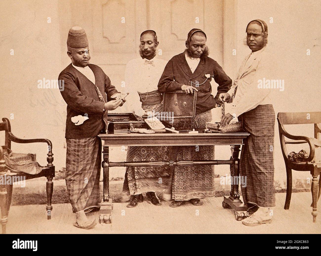 Galle, Sri Lanka: joyeros en vestido tradicional mostrando sus joyas en una  mesa. Fotografía, aprox. 1900.- Cingalese de letras Juweliers, Galle  Fotografía de stock - Alamy