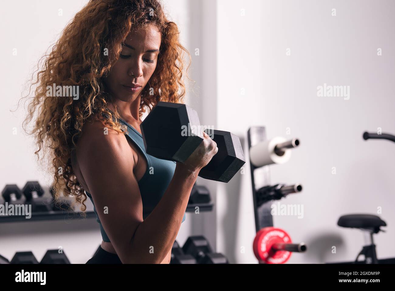 preparándose para el duro entrenamiento. mujer afroamericana con cabello  rizado y ropa deportiva tiene un día de fitness en el gimnasio 8457754 Foto  de stock en Vecteezy