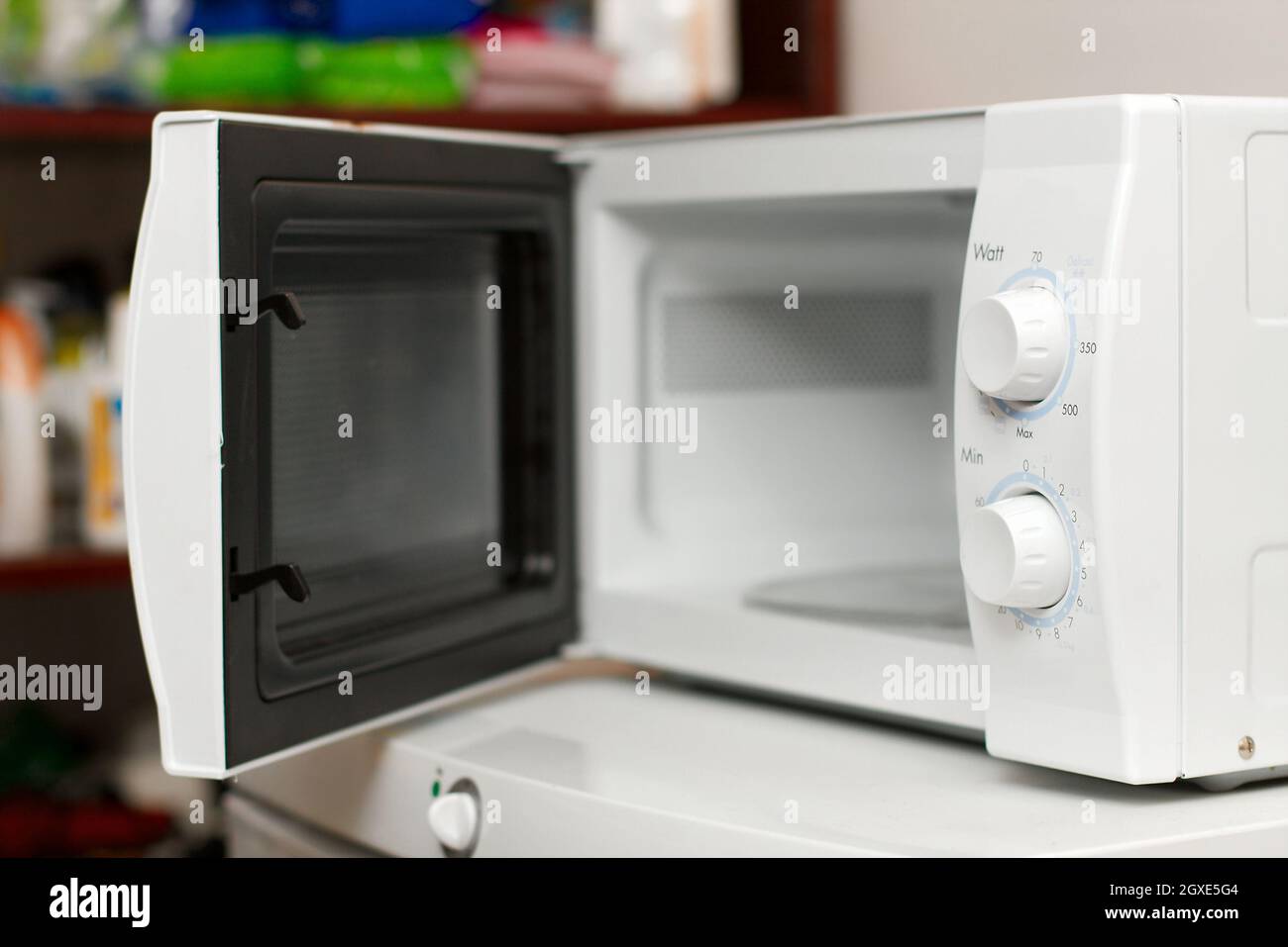 Horno de microondas vacío con puerta abierta en la parte superior de una  nevera Fotografía de stock - Alamy