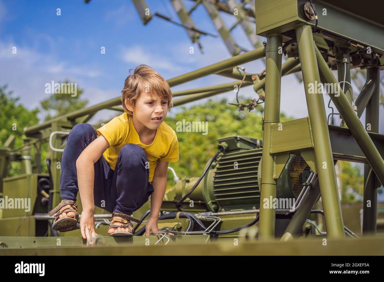Un niño está estudiando equipo militar. No hay guerra Foto de stock