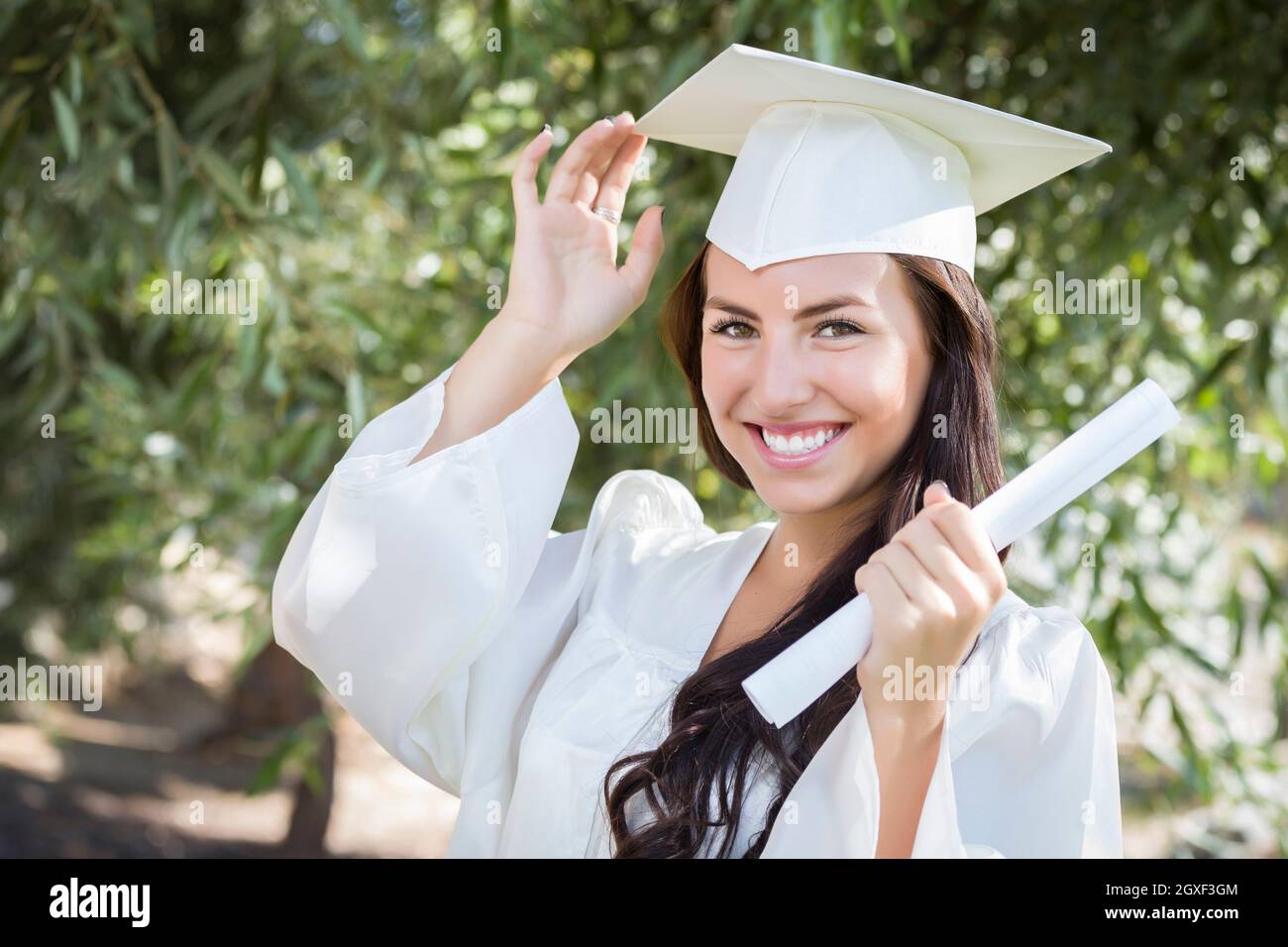 Atractiva Chica De Raza Mixta Celebra La Graduación Fuera De Toga Y Birrete Con Diploma En Mano 0599