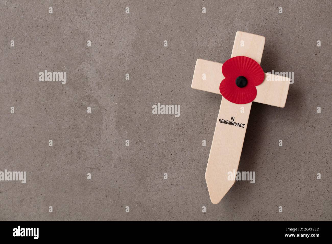 Un recuerdo de amapola roja en una cruz de madera. Concepto de día de recuerdo militar Foto de stock