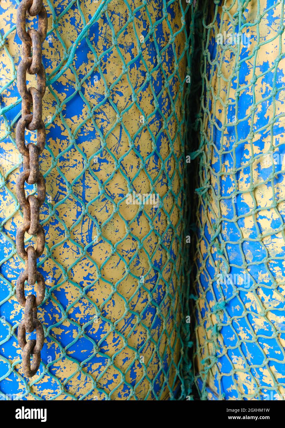 resumen de redes de pescadores envueltas alrededor de dos tambores de aceite Foto de stock