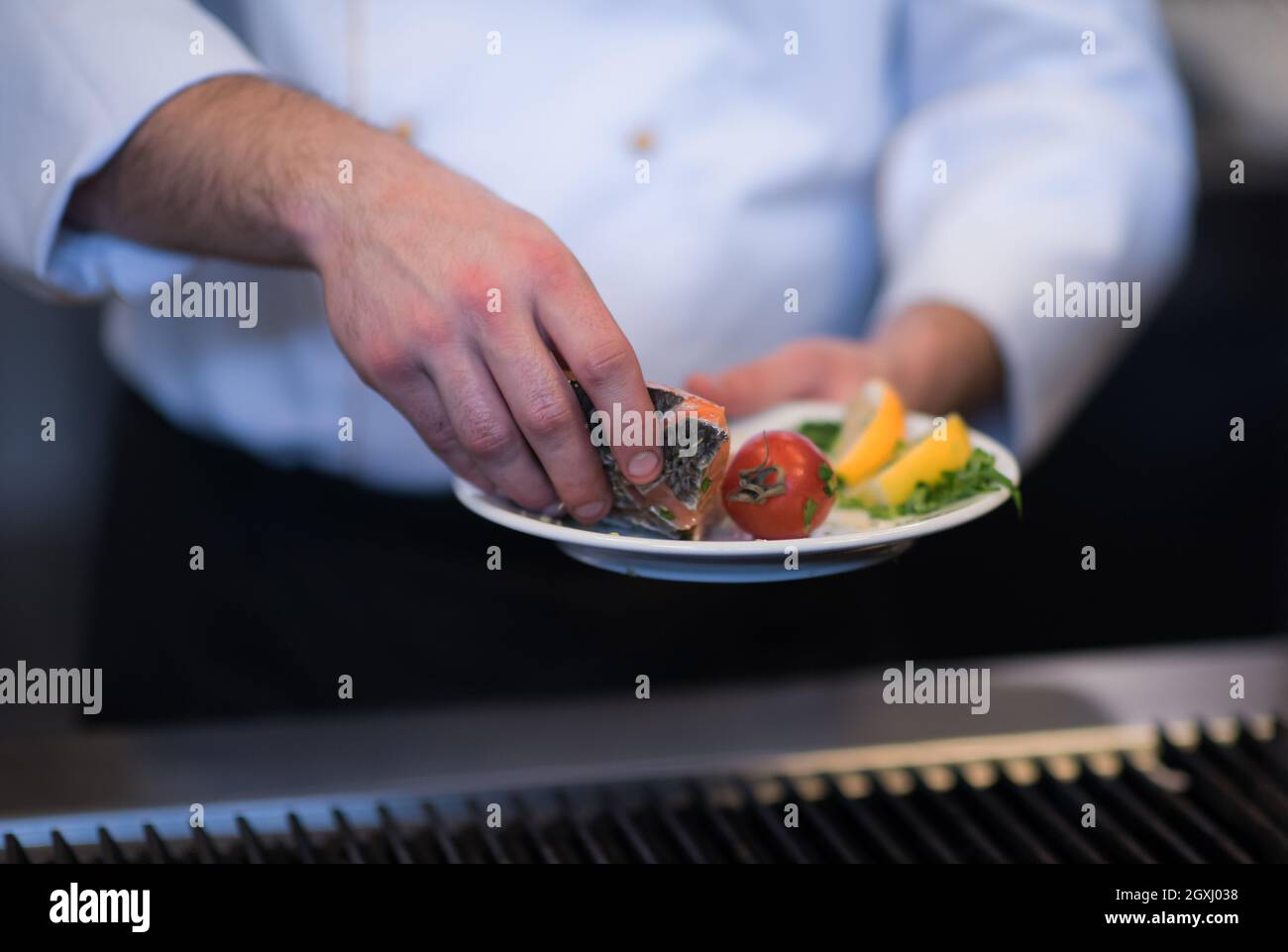 Master chef manos cocinar el salmón a la parrilla pescado con patatas en un  restaurante de cocina Fotografía de stock - Alamy