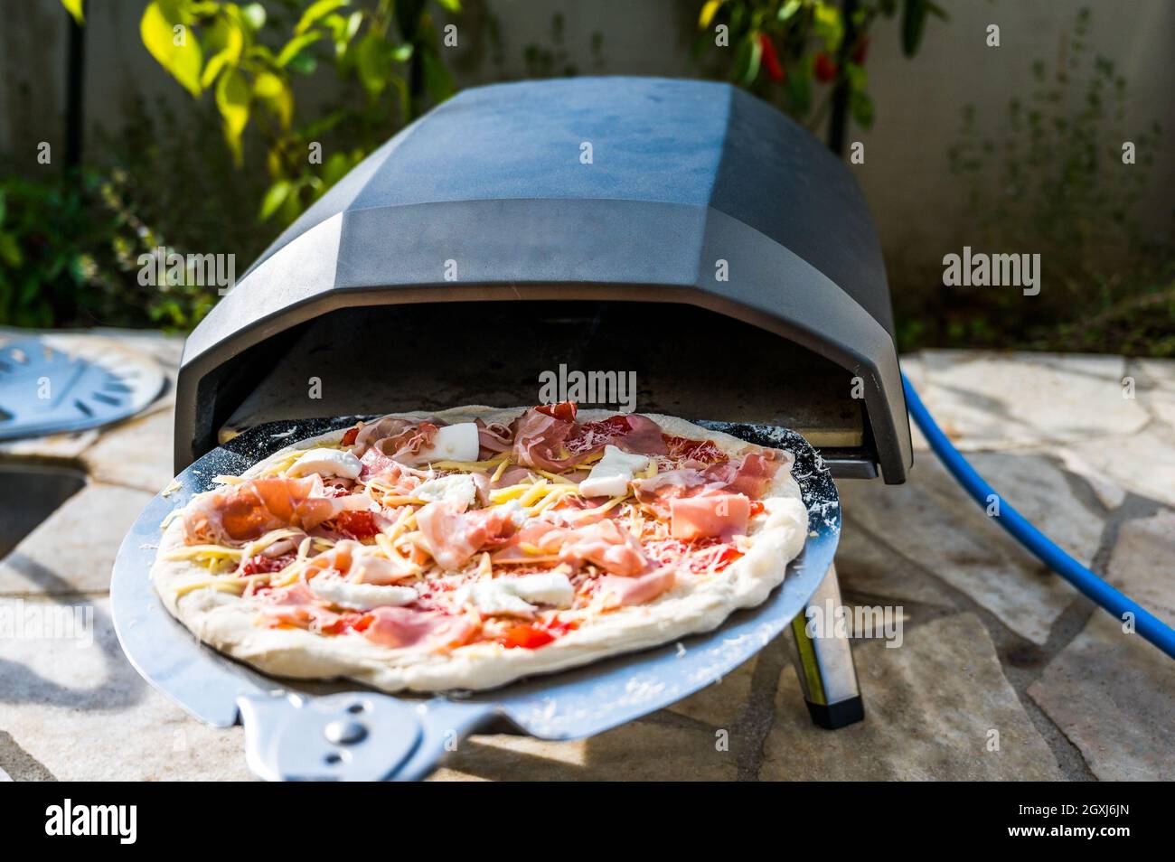 Elaboración de pizza casera en horno de gas portátil de alta temperatura.  Deliciosa pizza es horneada en horno de gas para pizza napolitana casera.  Especí Fotografía de stock - Alamy
