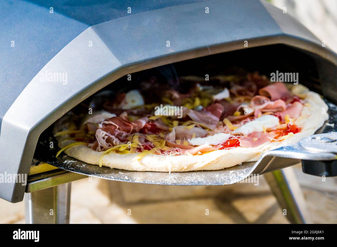 Elaboración de pizza casera en horno de gas portátil de alta temperatura.  Deliciosa pizza es horneada en horno de gas para pizza napolitana casera.  Especí Fotografía de stock - Alamy