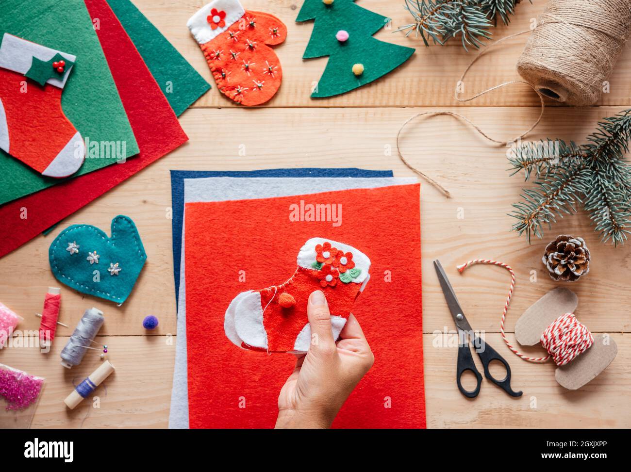 Una mano que sostiene bricolaje Navidad de fieltro de media, Navidad y Año  Nuevo artesanías para niños, Navidad de artesanía de ornamentos de fieltro  sobre fondo de madera Fotografía de stock -
