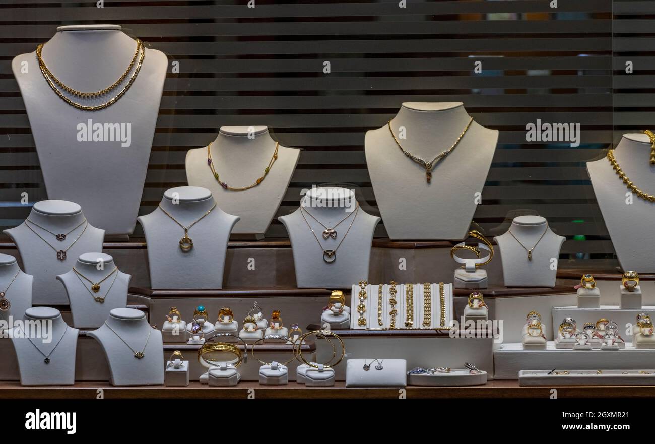 joyería ventana de la tienda con varios artículos de joyería hecha de oro y pendientes de plata collares y pulseras para la en una ventana de la tienda Fotografía de -