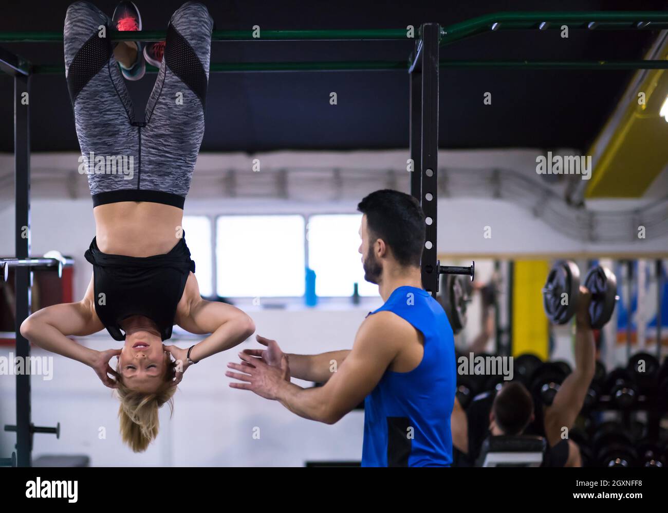 Atleta mujer realizando ejercicios de abs colgado boca abajo en la barra  horizontal en cruce de gimnasio Fotografía de stock - Alamy