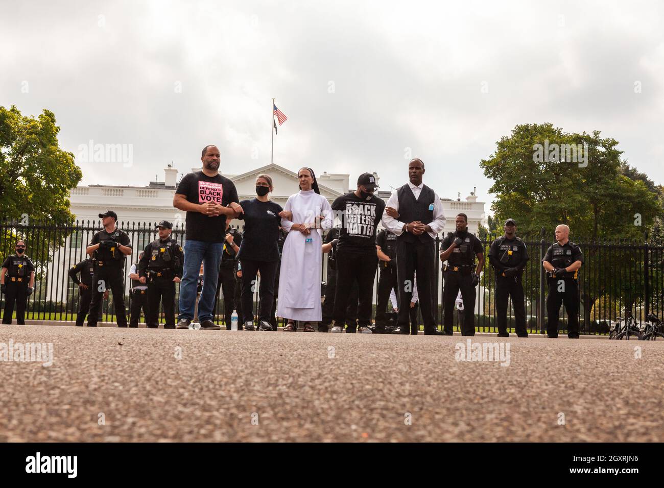 Washington, DC, EE.UU., 5 de octubre de 2021. En la foto: Activistas por los derechos de voto esperan ser arrestados por el Servicio Secreto de los Estados Unidos durante una acción de desobediencia civil en la Casa Blanca. Están exigiendo que la Administración de Biden tome la iniciativa en materia de derechos de voto y presionen al Congreso para que apruebe legislación que proteja el derecho de voto. Primera fila, de izquierda a derecha: Ben celoso de la gente para la manera americana, Noelle Damico de los trabajadores del círculo, hermana Quincy Howard de la democracia fiel, Cliff Albright de la materia negra de los votantes, y pastor Lewis Logan. Crédito: Allison Bailey / Alamy Live News Foto de stock