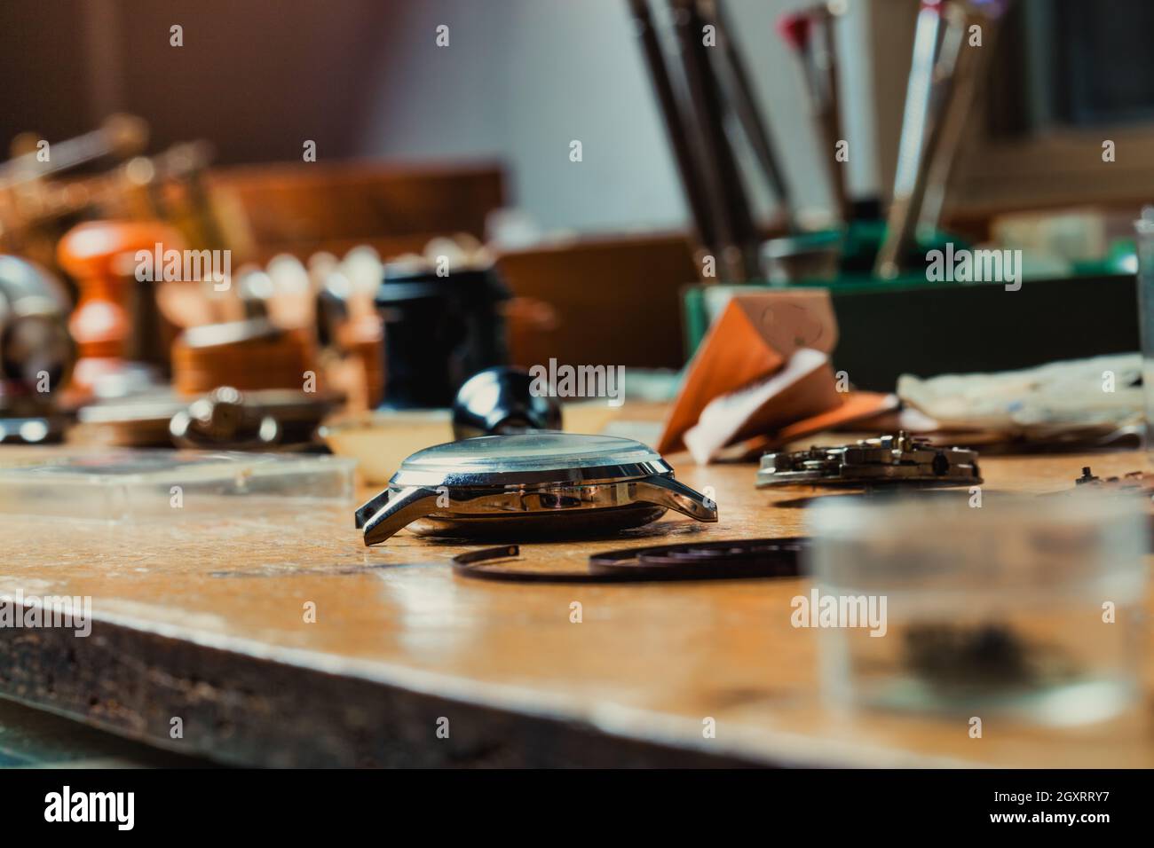 Vista en ángulo bajo de un reloj de pulsera en un banco de trabajo de relojeros, con enfoque selectivo y copyspace Foto de stock