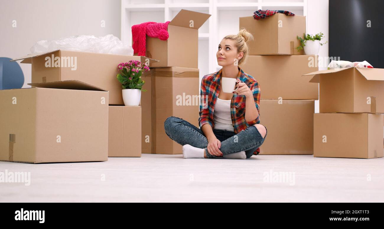 Las personas en movimiento, lugar nuevo y reparar el concepto feliz joven  hermosa con muchas cajas de cartón sentados en el suelo con la copa en casa  Fotografía de stock - Alamy