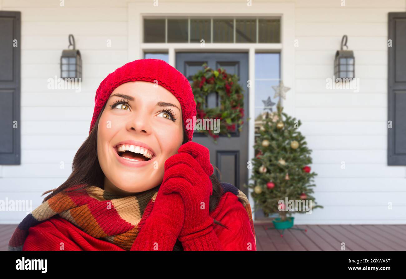 Niña llevar bufanda, gorra roja y mitones de pie en el Porche decorado de Navidad Fotografía de stock Alamy