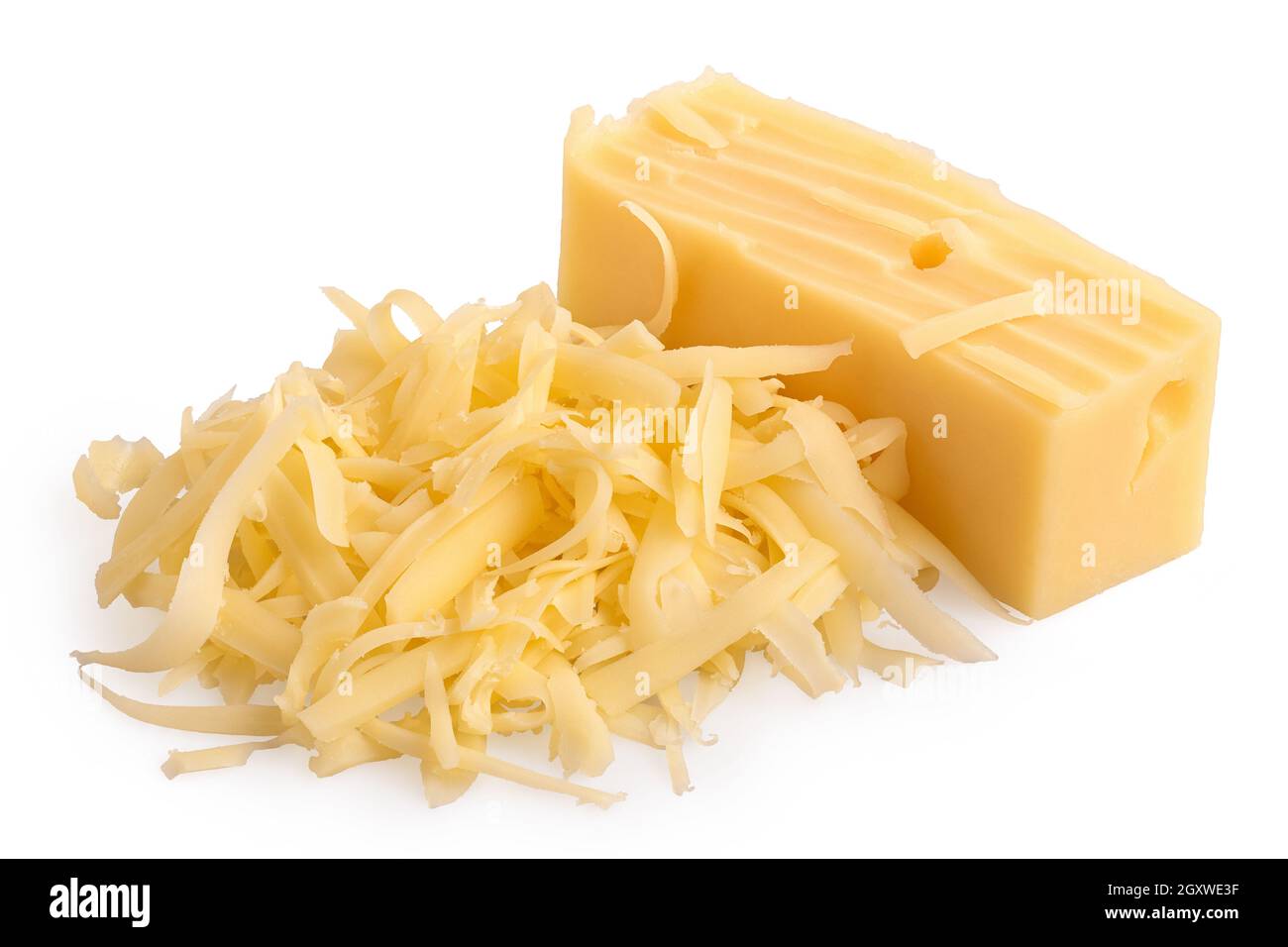 Montón de queso rallado junto a un bloque de queso. Foto de stock