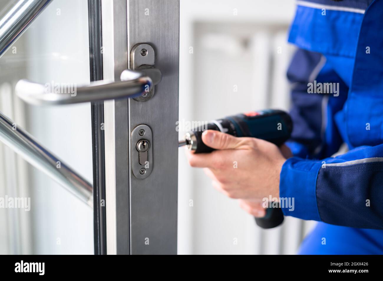 Hombre cerrajero Reparación y cambio de cerradura metálica de puerta  Fotografía de stock - Alamy