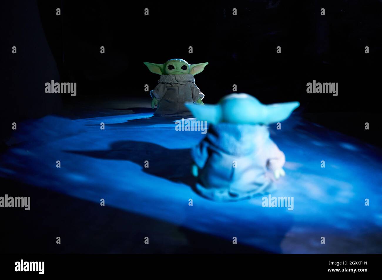 Octubre de 2021: Baby Yoda, figuras de acción de Star Wars y su reflejo en  el espejo. Cielo azul de fondo Fotografía de stock - Alamy