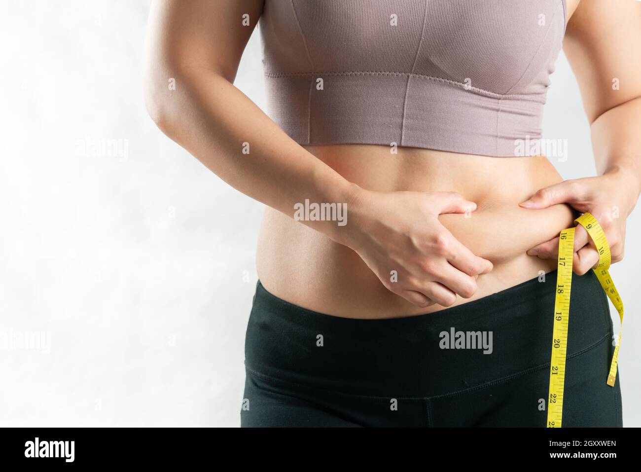 Mujer joven muestra su vientre caído después de perder peso y