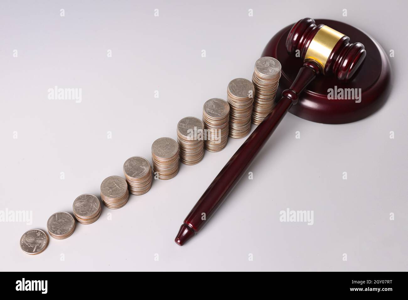 Gavel juez de madera y montones de monedas en la mesa Foto de stock