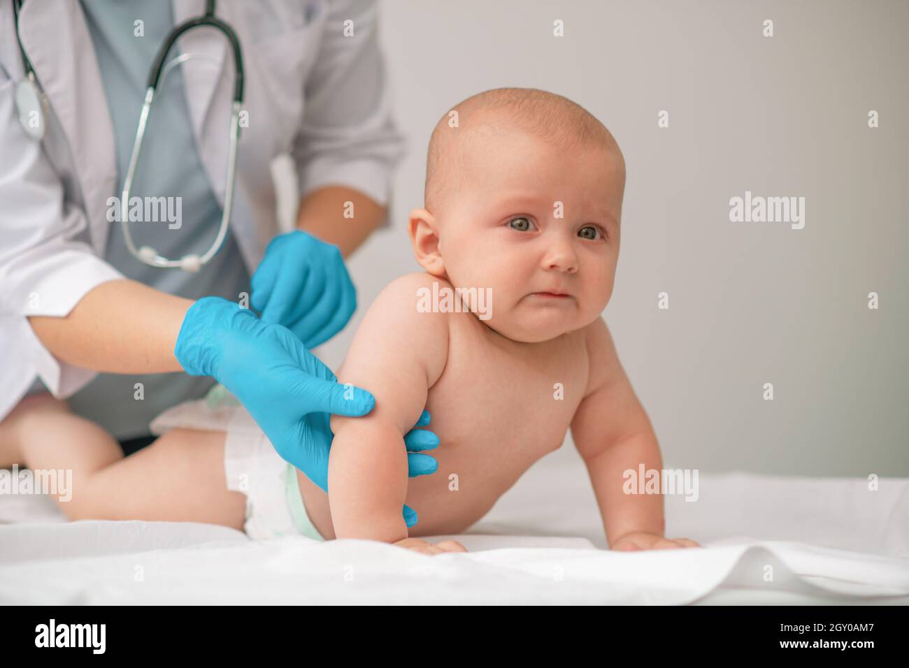 Bebé Asustado Es Examinado Por Un Profesional Sanitario Imagen de