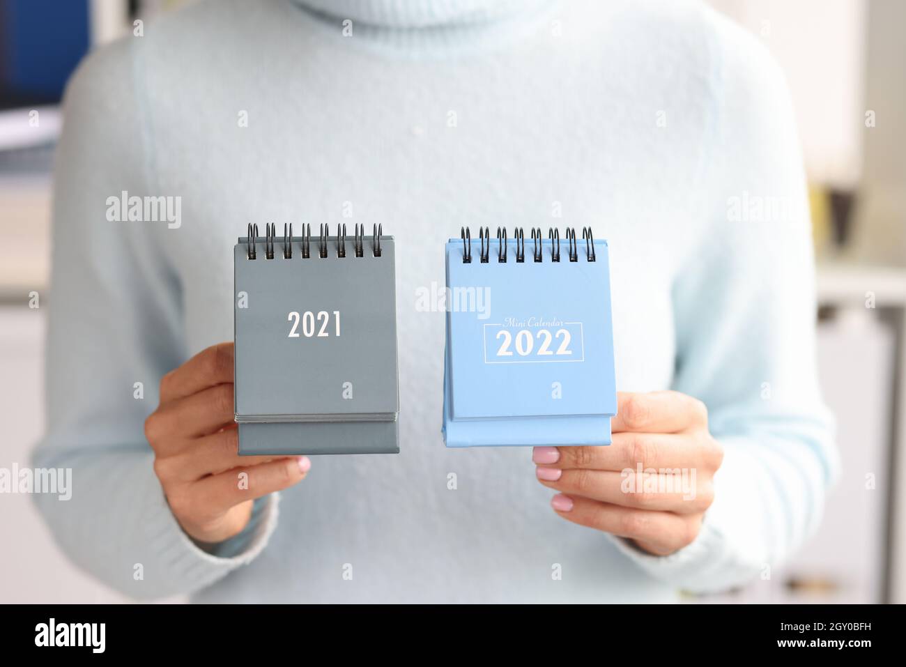 Mujer sosteniendo el calendario 2021 y 2022 cierre. Cambio de año calendario Foto de stock
