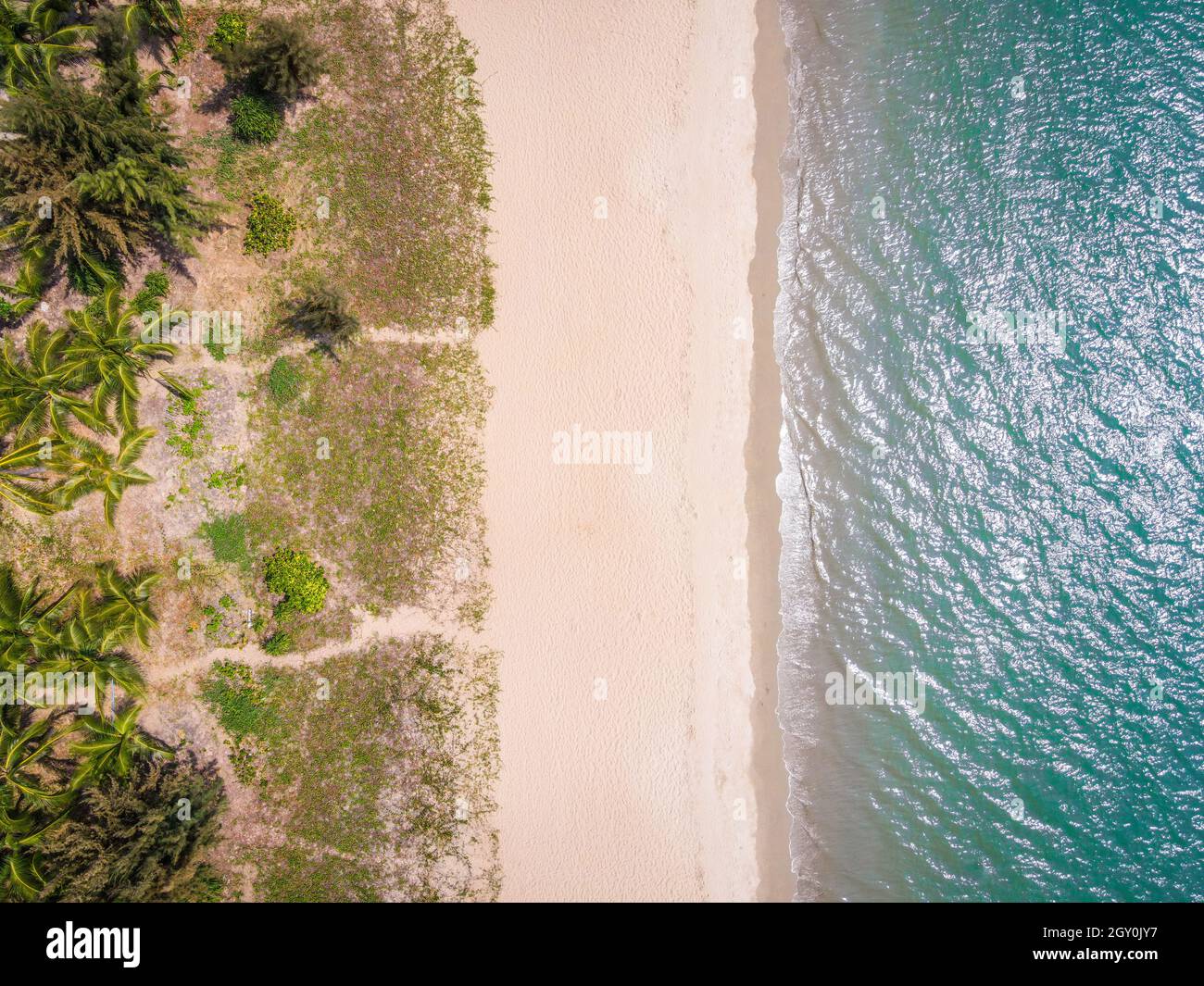 Toma aérea de la parte superior del drone de la playa vacía de la bahía de Sanya con arena blanca y agua en la isla tropical de Hainan China Foto de stock