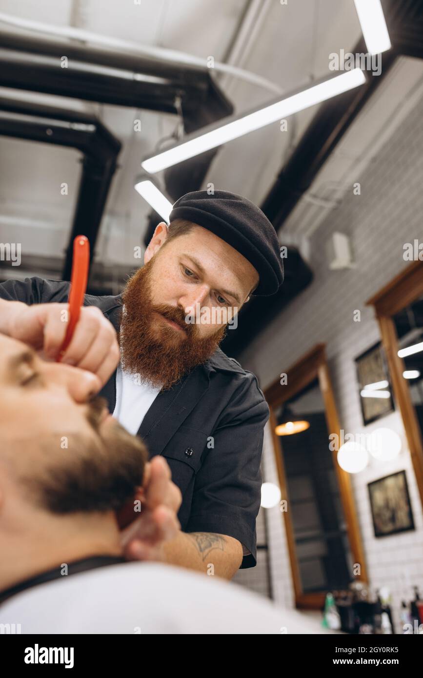 Apuesto Peluquero O Utiliza La Barba Corta Barba Hombre Con El Cliente De  Corte De Teléfono No Se Sienta En Silla En Barbería O Salón De Peluquería  Fotos, retratos, imágenes y fotografía