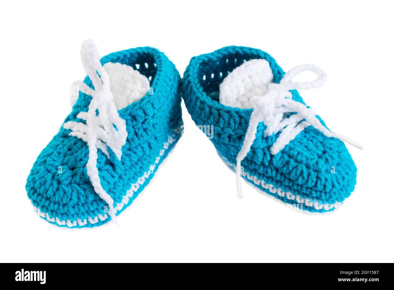 Botas de bebé de punto aisladas. Zapatos pequeños hechos a mano azules para  un recién nacido sobre fondo blanco. El concepto de maternidad, la  aparición del primer árbol Fotografía de stock -