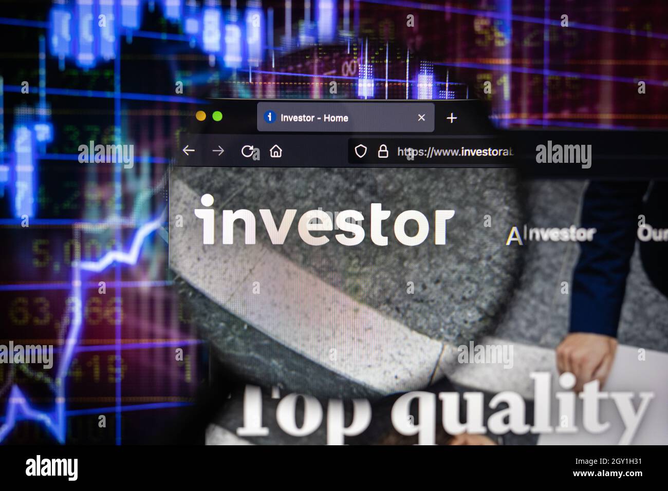 El logotipo de la empresa del inversor en un sitio web con la evolución borrosa del mercado de valores en el fondo, visto en una pantalla de ordenador a través de una lupa Foto de stock