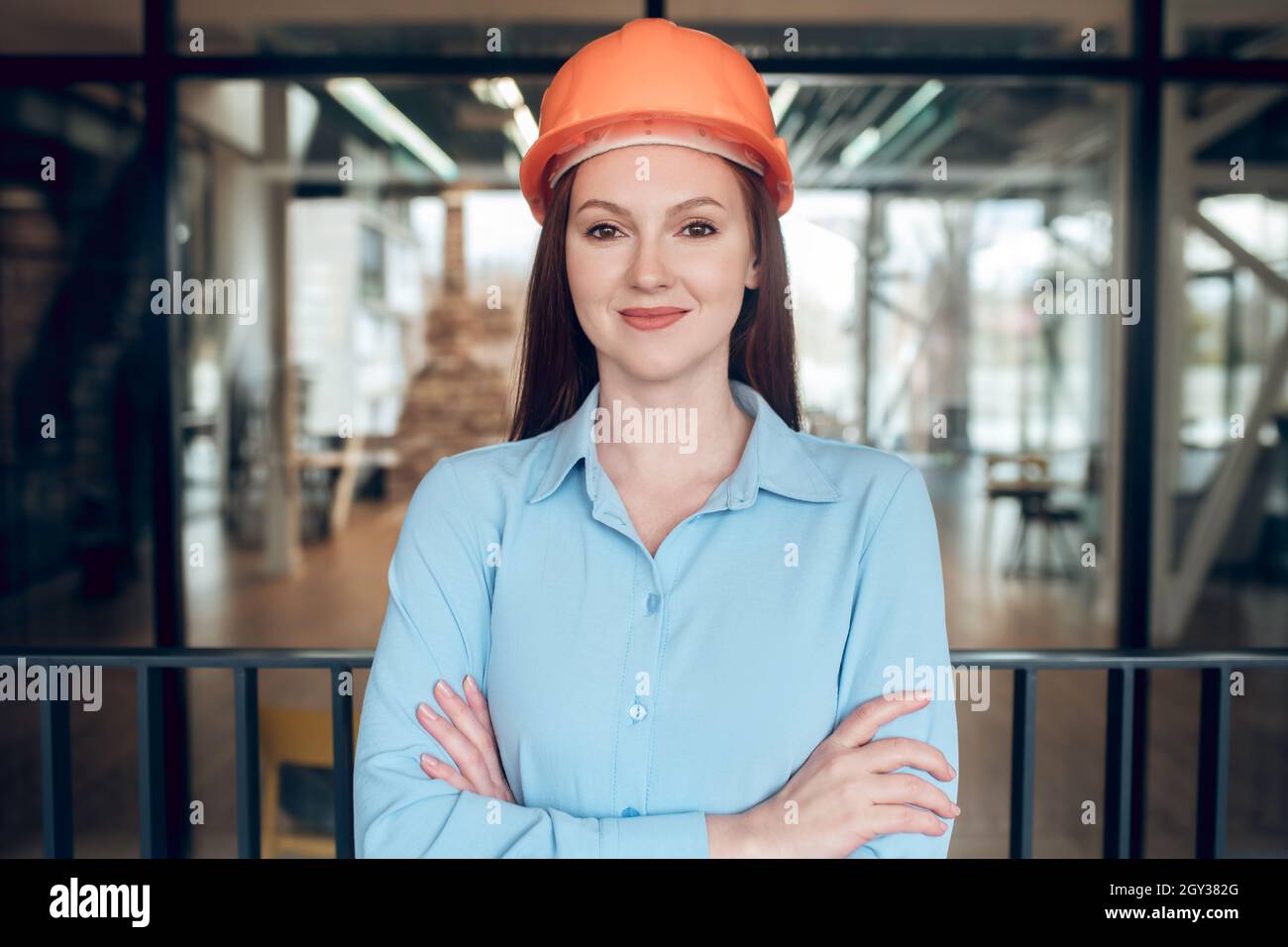 Mujer joven optimista en casco de seguridad Foto de stock