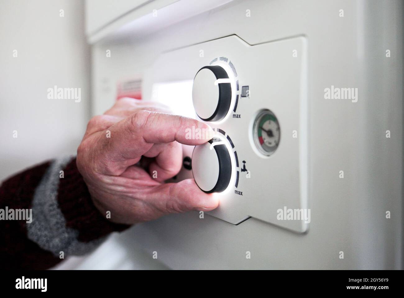 Un pensionista que ajusta el control de temperatura en su caldera combinada. Redcar, Reino Unido. 26/5/2021. Fotografía: Stuart Boulton. Foto de stock