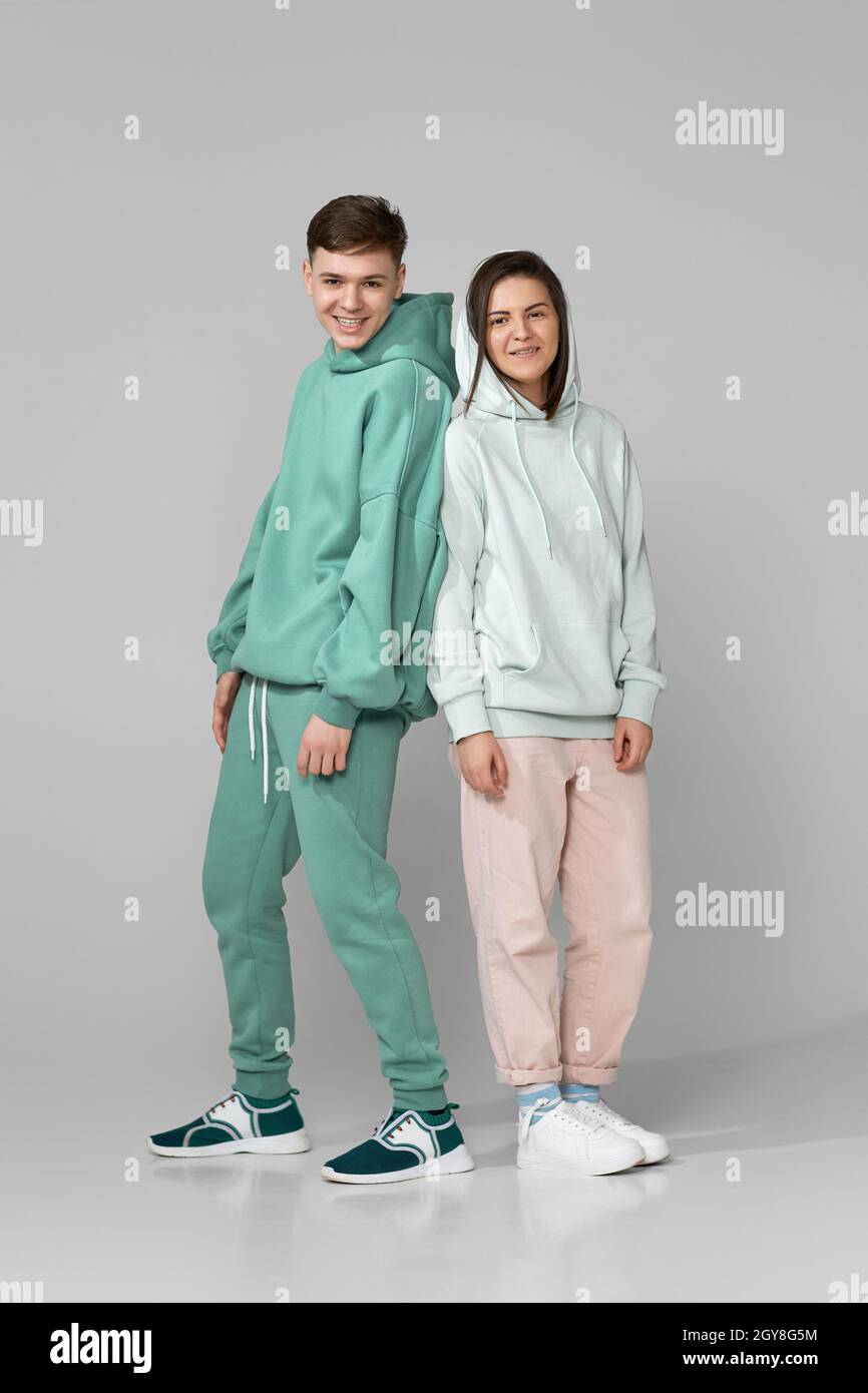 dos amigos hombre mujer con ropa de menta verde sport sudadera con capucha  fondo gris Fotografía de stock - Alamy