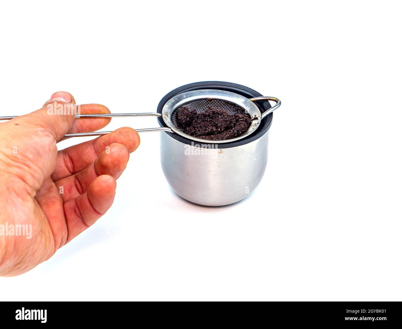 Un colador para filtrar el café o el té se vierte en una taza