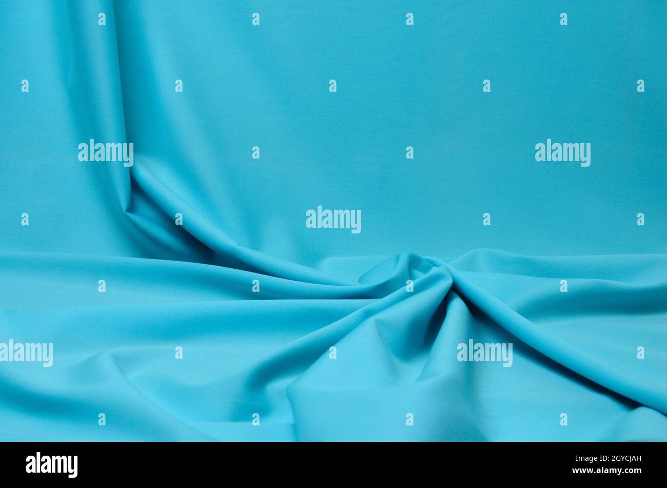 Fondo texturizado de tejido azul suave con pliegues elegantes. Enfoque selectivo. Foto de stock
