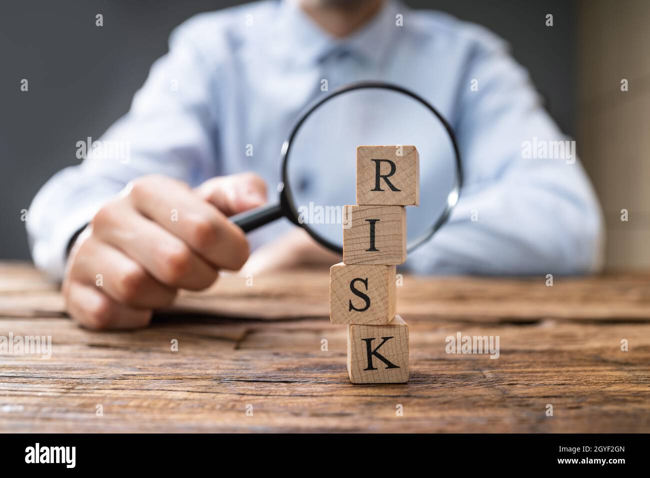 Medida de riesgo económico con lupa. Gestión de riesgos Foto de stock