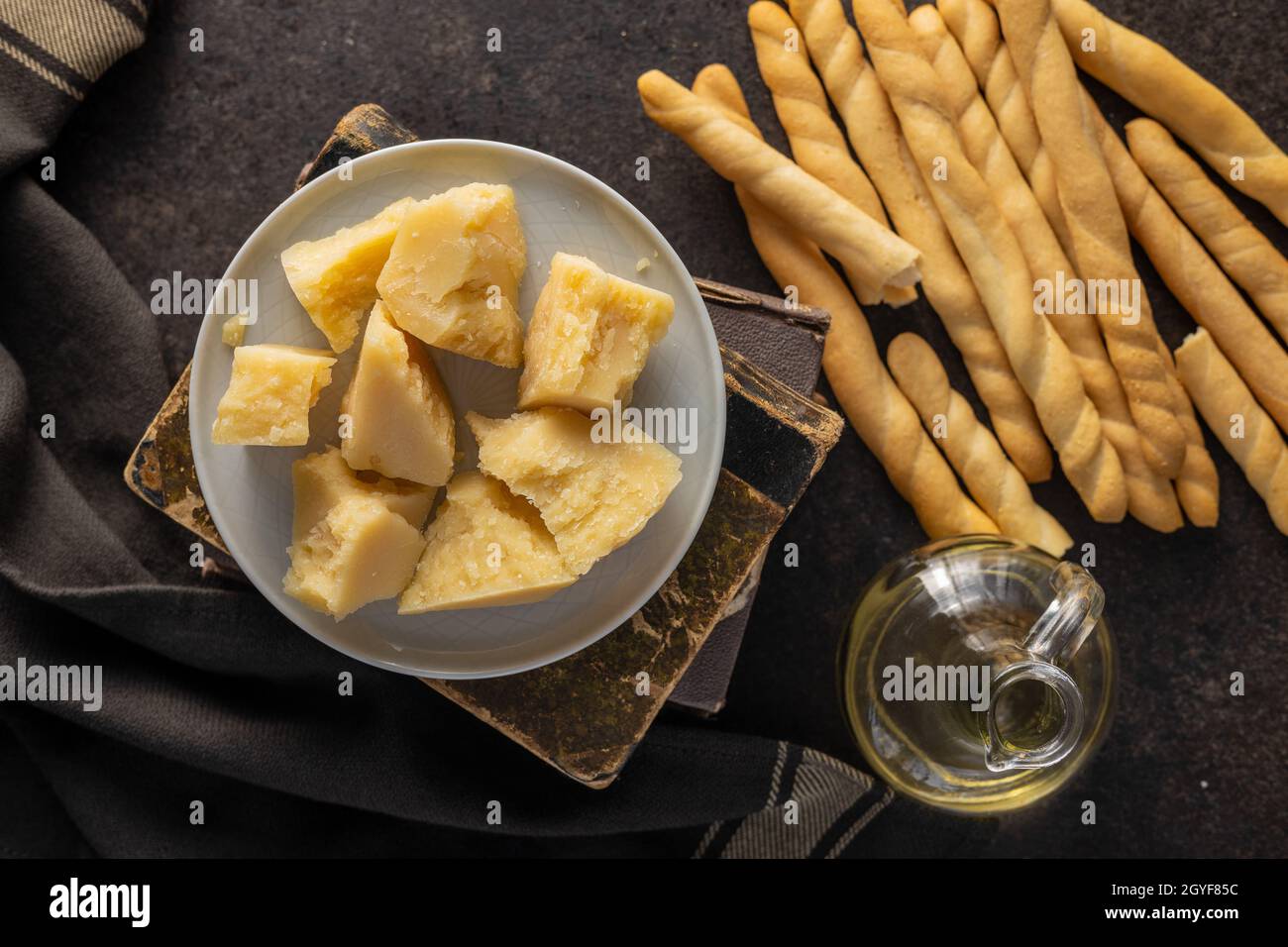 Palos de grissini y queso parmesano. Comida tradicional italiana sobre mesa negra. Vista superior. Foto de stock