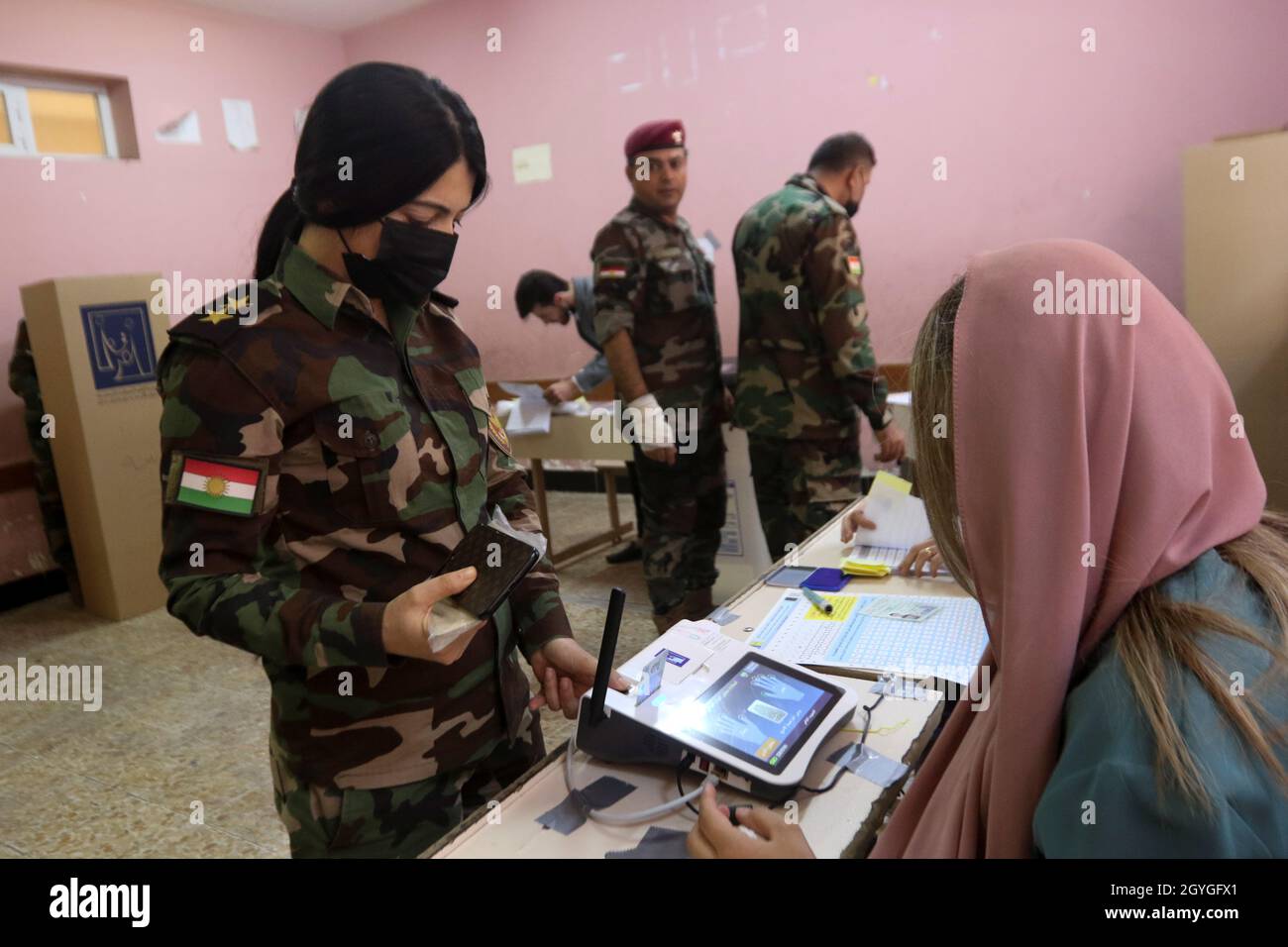 Un miembro de las fuerzas militares kurdas de Peshmerga se prepara para  emitir su voto dentro de una mesa electoral, dos días antes de las  elecciones parlamentarias de Irak en un proceso