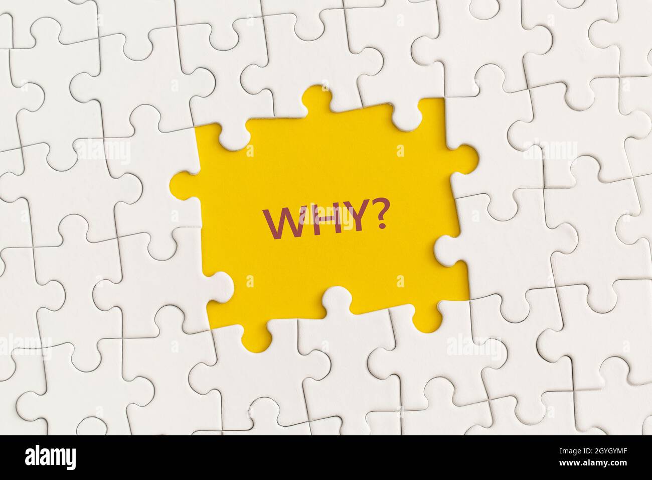 Detalles blancos del rompecabezas con el texto '¿Por qué?' sobre fondo amarillo. Foto de stock