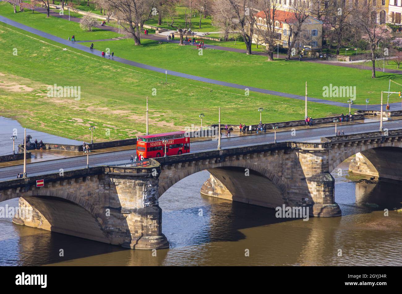 Dresde, Sajonia, Alemania: Un autobús rojo de dos pisos de una compañía turística local cruza el Puente de Augusto. Foto de stock