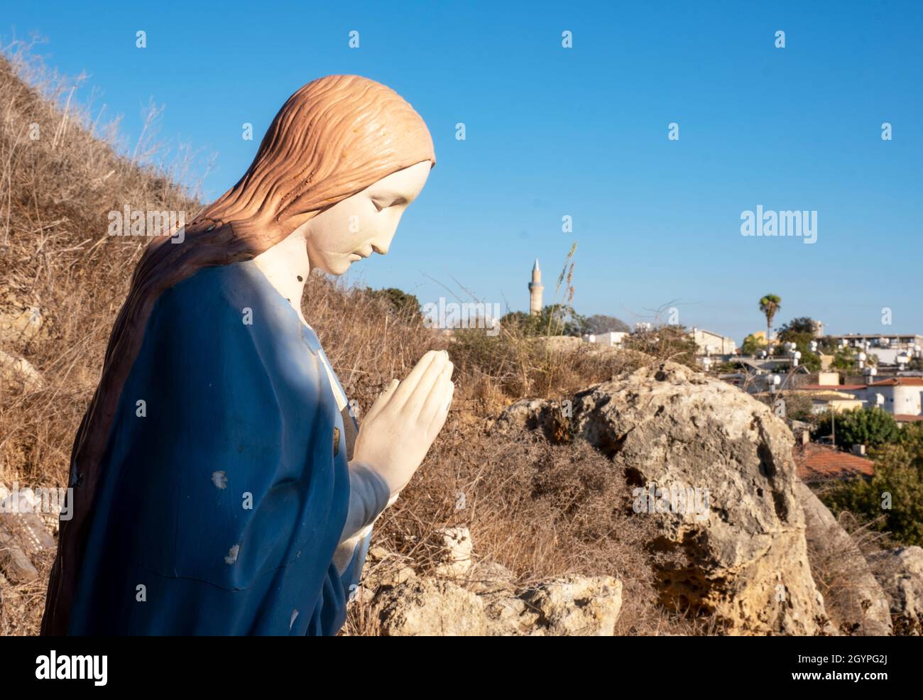 Estatua religiosa cristiana detrás del pequeño santuario y capilla, Kâmil Toçan, Moutallos, Paphos, Chipre. Foto de stock