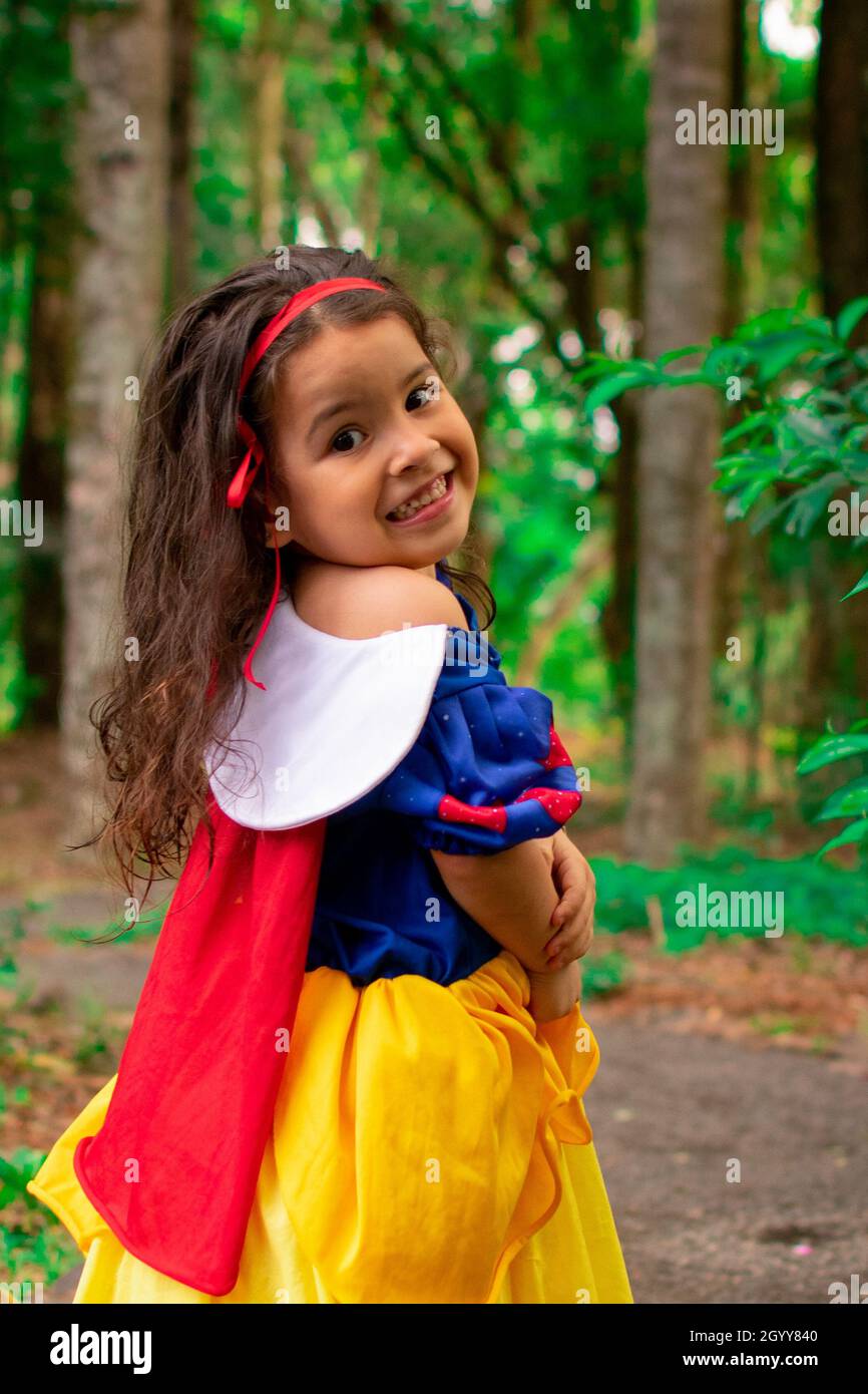 Una linda niña hispana con un vestido de Blanca Nieves como su traje de  Halloween en un bosque Fotografía de stock - Alamy