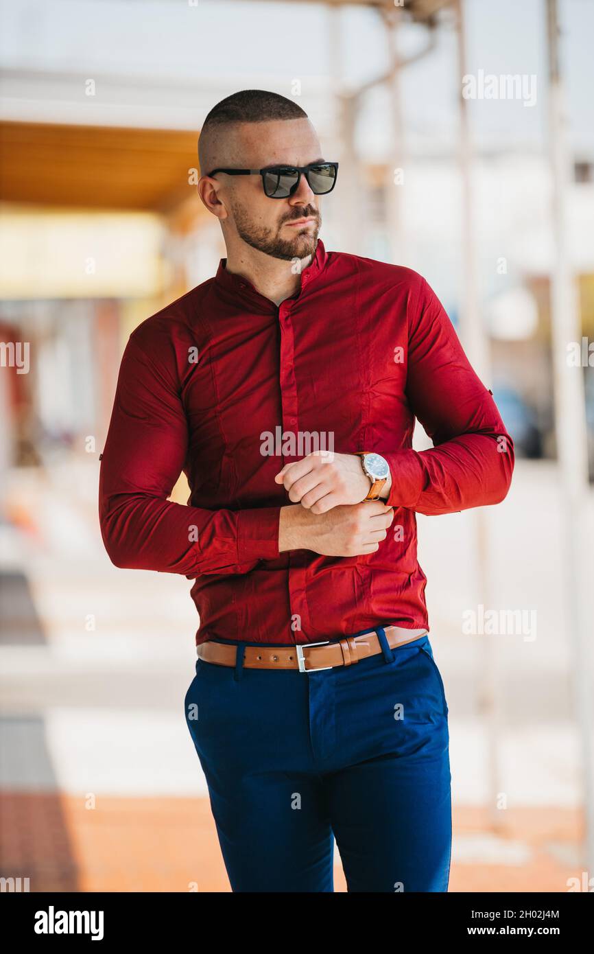 Hombre caucásico fresco guapo que lleva una elegante camisa roja y gafas de  sol posando al aire libre Fotografía de stock - Alamy