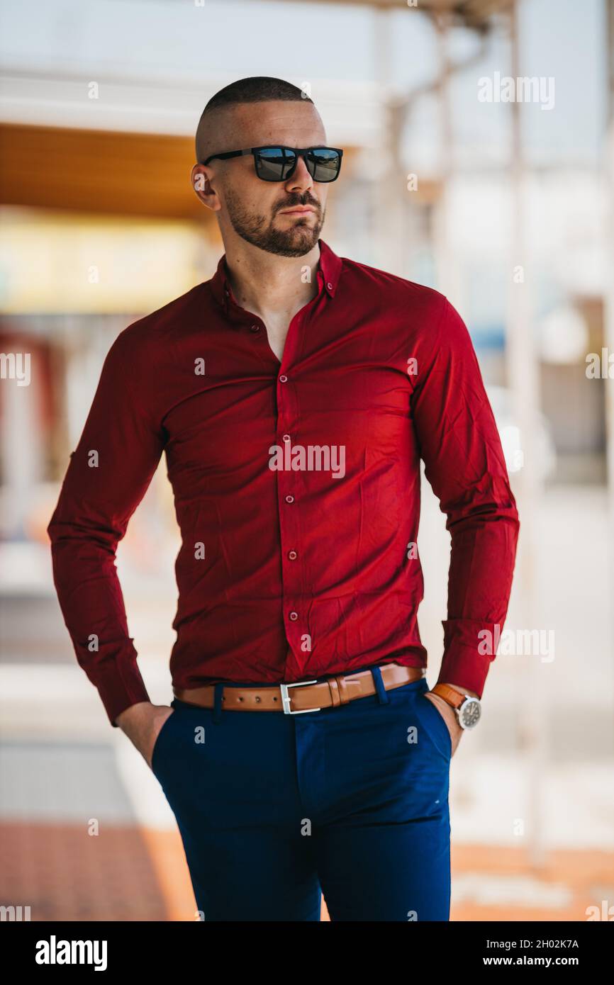 Ganar parque etiqueta Hombre caucásico fresco guapo que lleva una elegante camisa roja y gafas de  sol posando al aire libre Fotografía de stock - Alamy