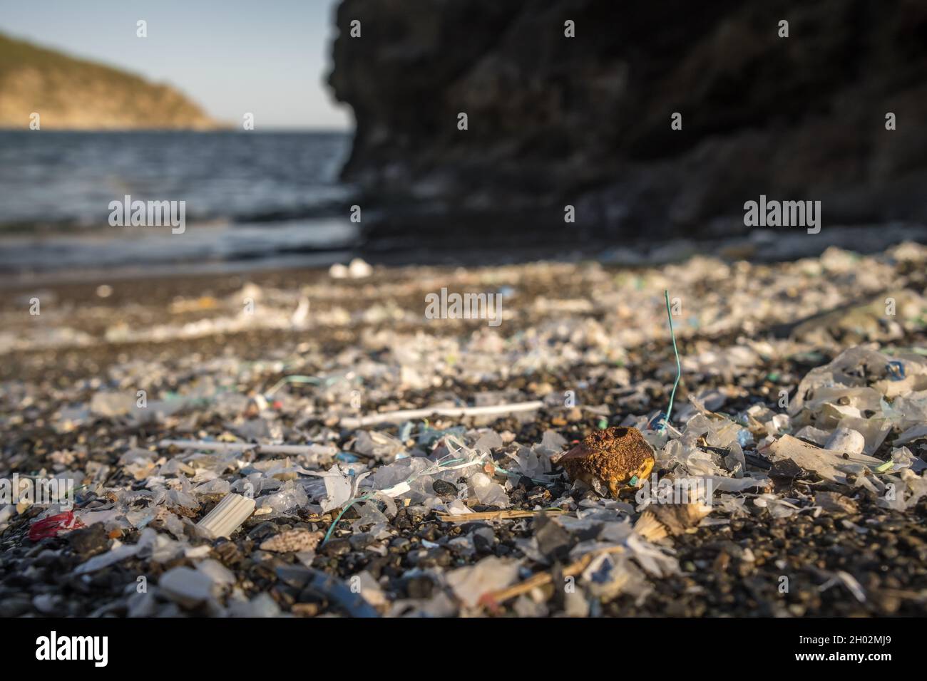 Pequeñas piezas de plástico y microplásticos en la playa de arena Foto de stock