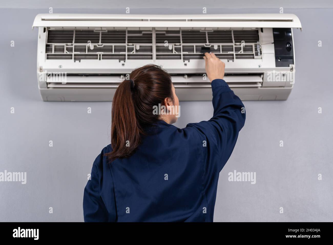 servicio técnico con cepillo para limpiar el aire acondicionado en  interiores Fotografía de stock - Alamy