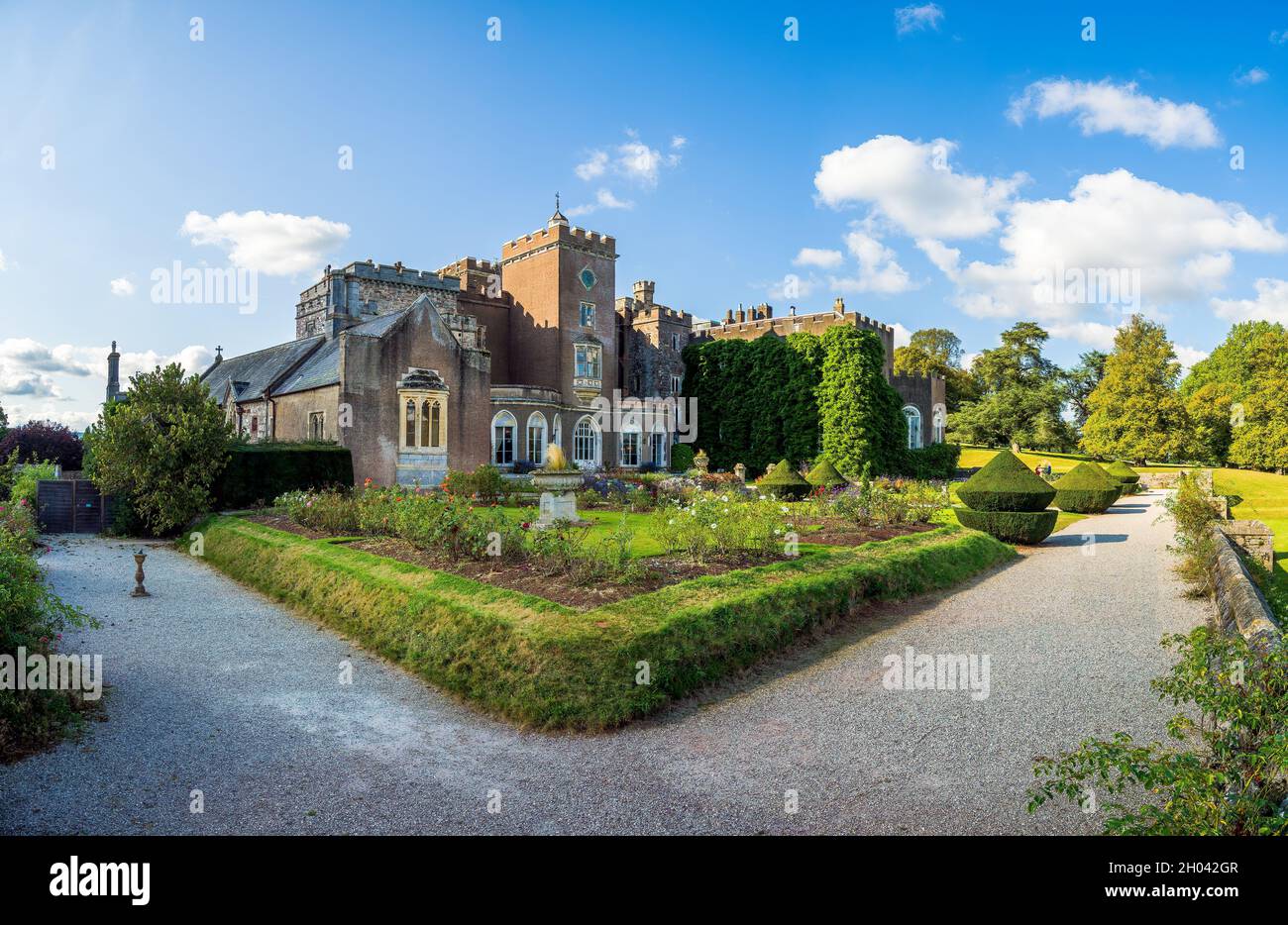 Antigua casa y castillo con jardín de rosas en Devon Foto de stock