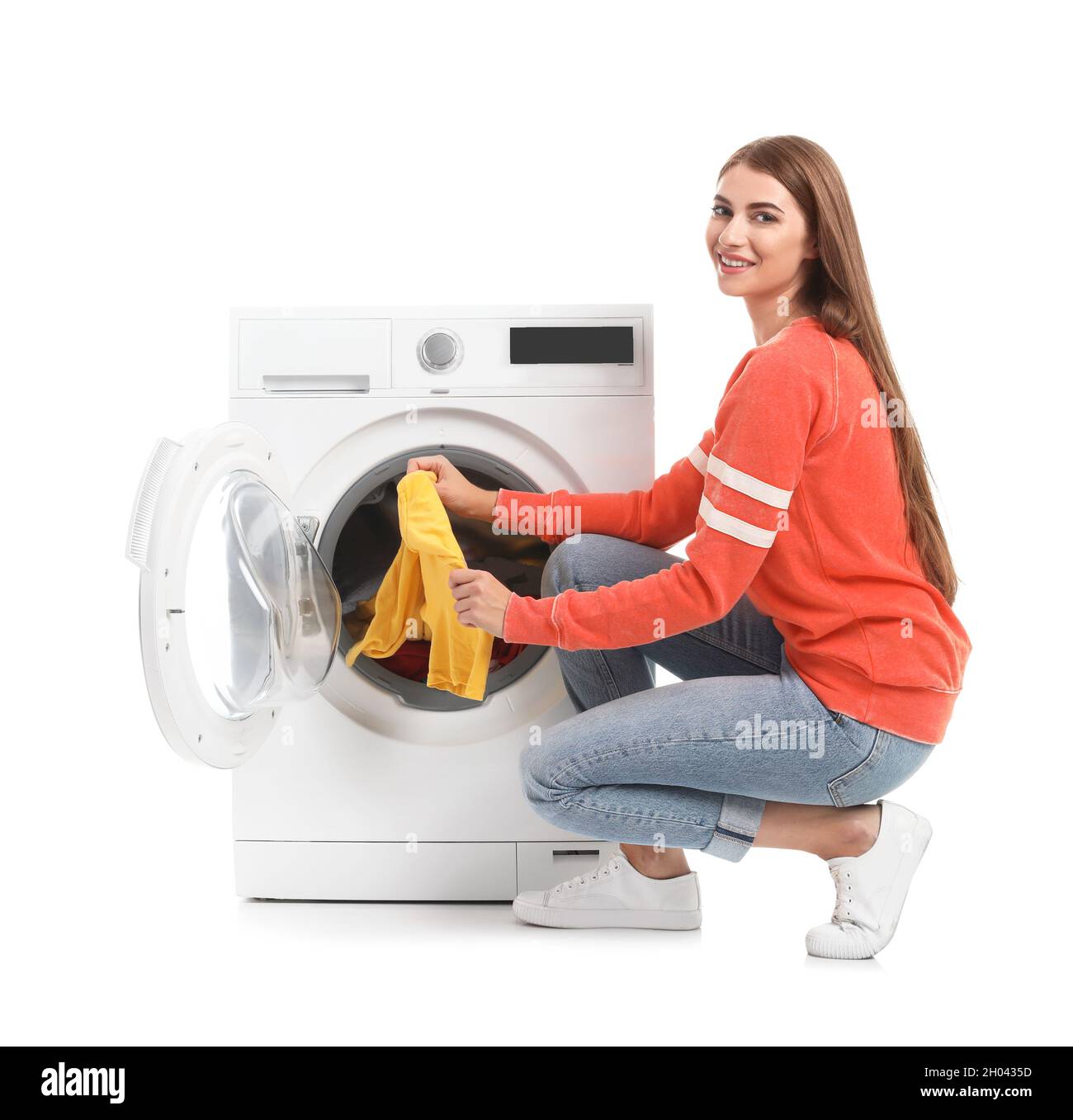 Mujer joven sacando la ropa de la lavadora sobre fondo blanco Fotografía de  stock - Alamy