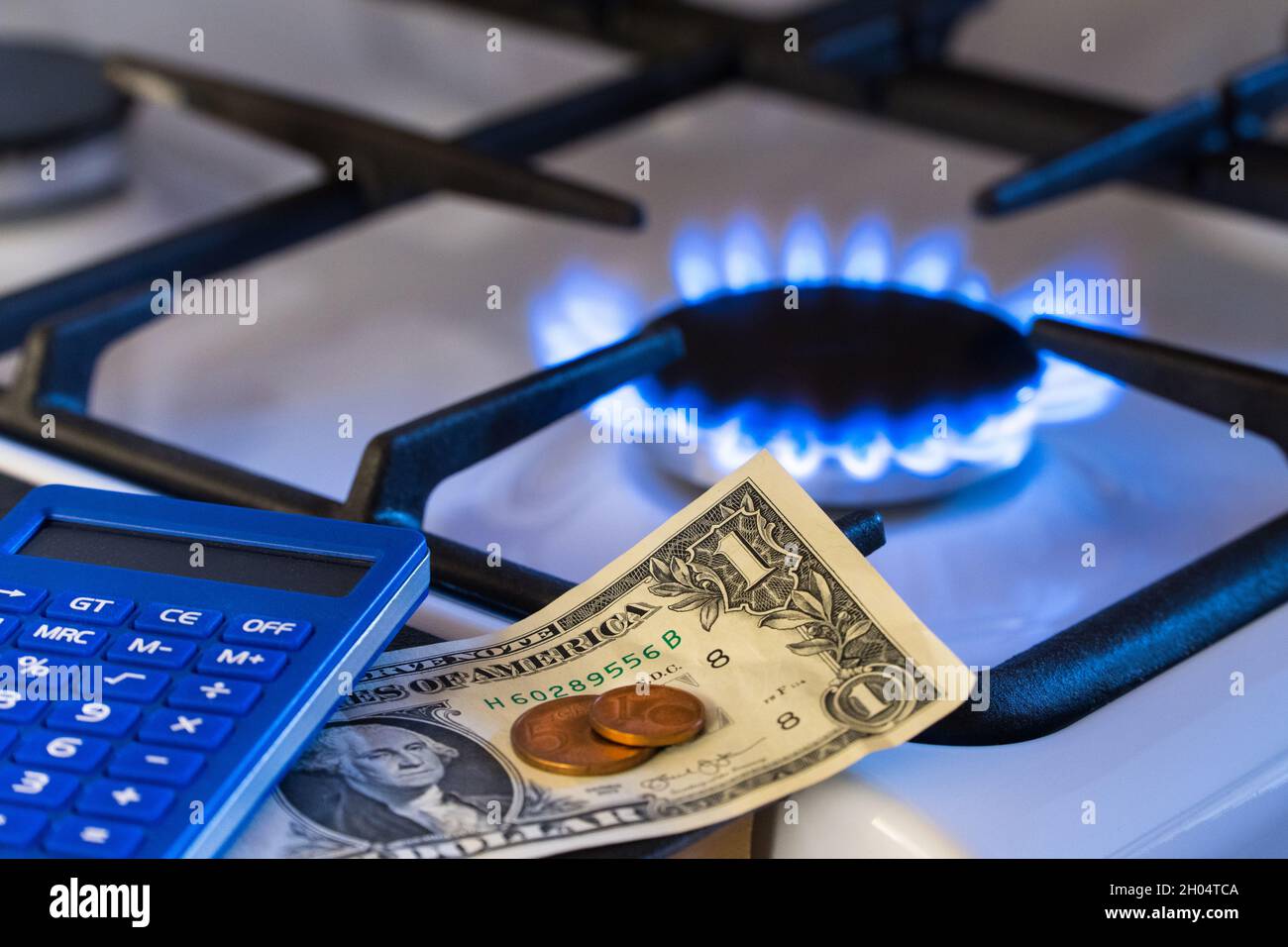 Escasez y crisis del gas. Dinero y una calculadora en el fondo de una estufa  a gas Fotografía de stock - Alamy